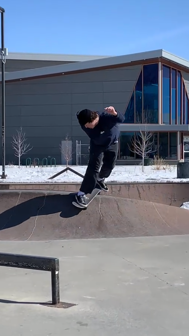 person doing skateboard trick in front of building