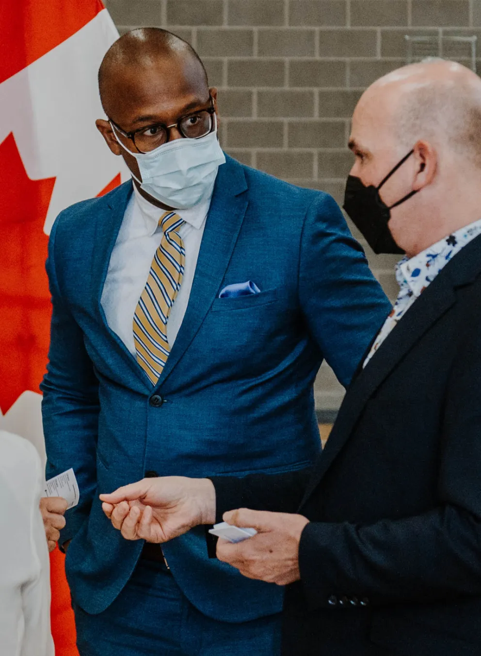 A group of well-dressed men and women stand together after a media event.