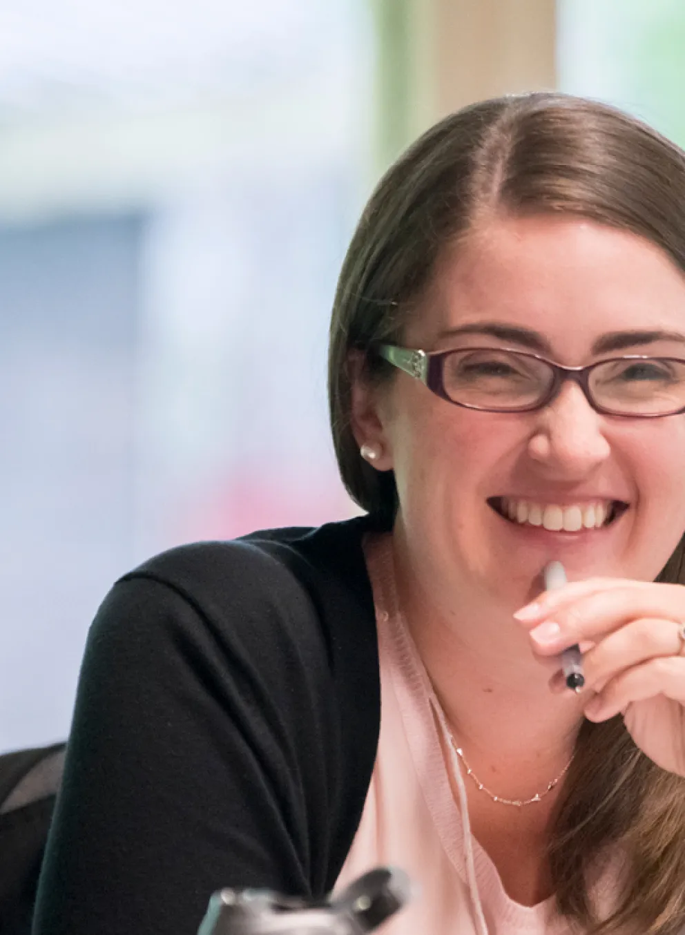 A group of women sit together at a table indoors.