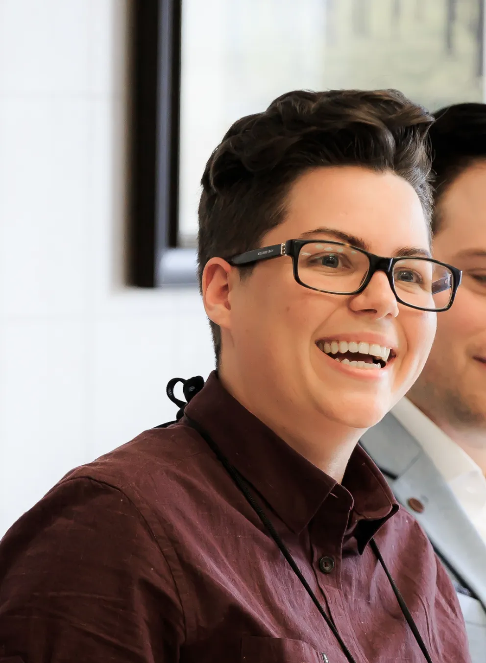 A group of well dressed young adults sit at a head table during a conference.