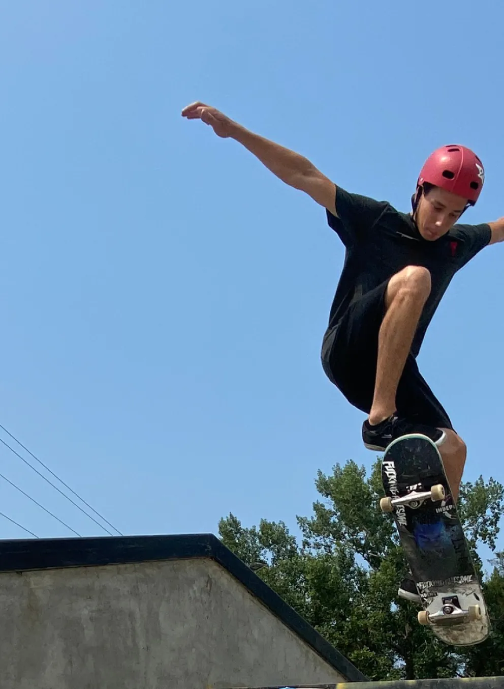 A young man rides a skateboard over an outdoor staircase and winds up for a trick.