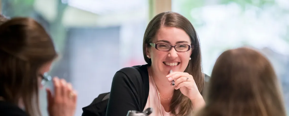 A group of women sit together at a table indoors.