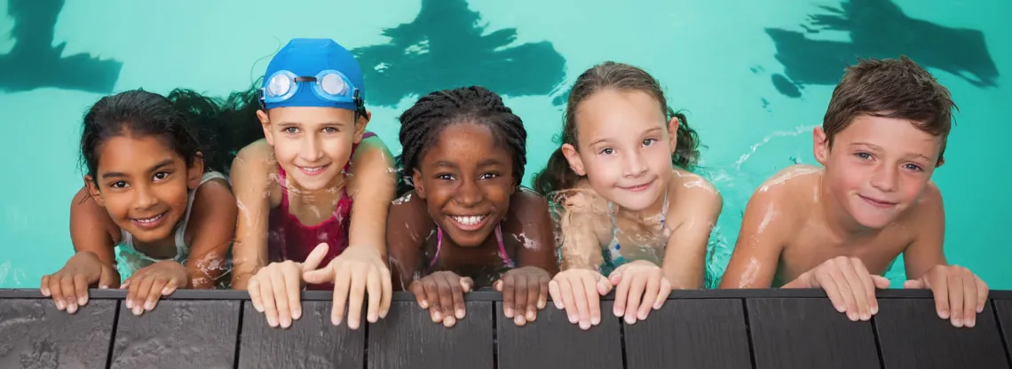 Kids with smiling faces posing for a photo during Swim Lessons